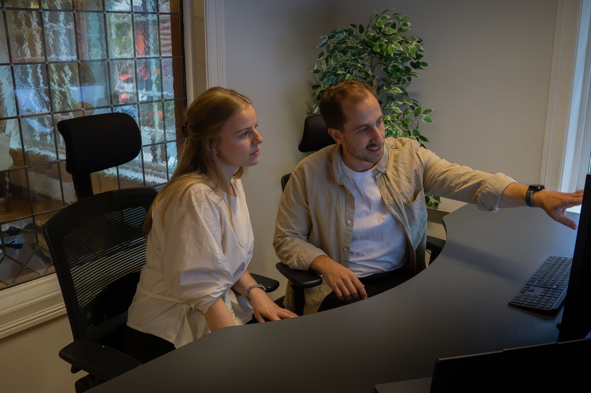Teamet i Nlytics jobber sammen foran en skjerm.